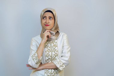 Endonezyalı Müslüman kadın, Beyaz Arkaplanda Ramazan kıyafetiyle jest yapmayı düşünüyor