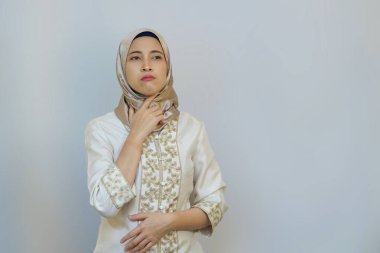 Endonezyalı Müslüman Kadın Ramazan ayında Beyaz Arkaplanda Oruç Tutarken Susuzluk ve Rahatsızlık İfade Ediyor