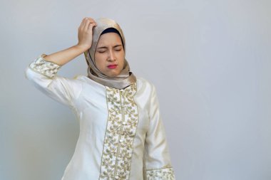 Beyaz arka planda Ramazan boyunca migren ağrısı çeken Endonezyalı Hijabi Kadını