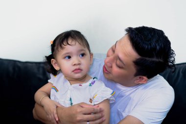 Baba kız kaynaşıyor, birlikte oynuyorlar, kanepede uzanıyorlar..