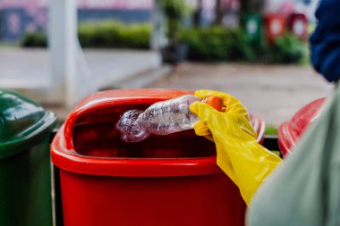 Çöp kutusuna plastik şişe atmak, çöp öğütme konsepti..