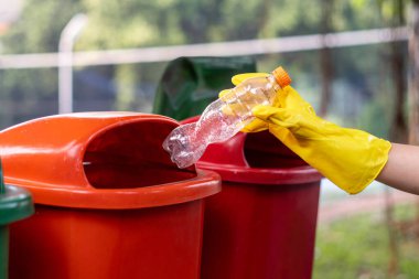 Çöp kutusuna plastik şişe atmak, çöp öğütme konsepti..