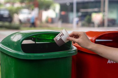 Plastik bardağı çöp kutusuna atmak, atık öğütme konsepti..