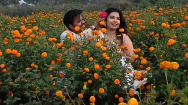 Çiçeklerdeki Romantik Çift. Marigold Çiçek Tarlası. Keyfin bilir. Erkek arkadaş ve kız arkadaş. O ve kadın. Sevgililer Günün kutlu olsun. Hintli Çift