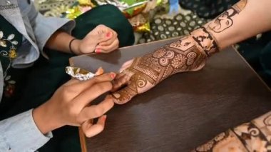 henna tattoo on legs. Bridal mehendi for legs. Indian marriage. Henna tattoo applying.