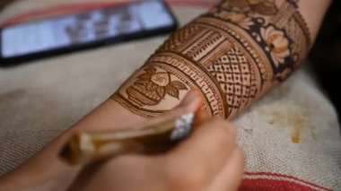 henna tattoo on hands close up. Bridal mehendi in process. Indian marriage. Henna tattoo applying.