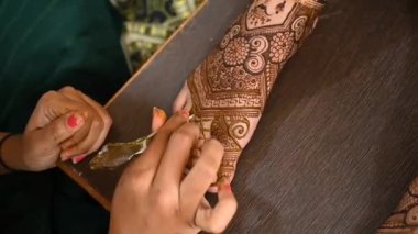 Beautiful henna tattoo on legs for bride. Bridal mehendi for legs. Indian marriage. Henna tattoo applying.