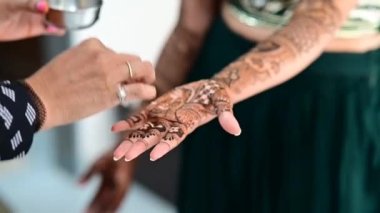 Apply lemon juice and oil on henna tattoo on hands close up for colors. Bridal mehendi in process. Indian marriage. Henna tattoo applying.