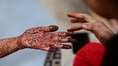 Henna tattoo on hands close up for fingertips. Bridal mehendi in process. Indian marriage. Henna tattoo applying.