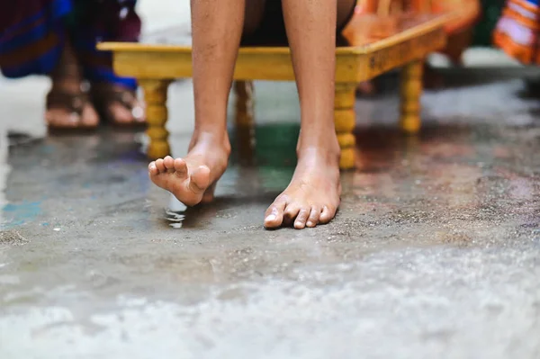 Wet Feet of Boy Bathing for hindu worship ceremony. Holy spring water. Indian boy thread ceremony rituals. Maharashtra culture