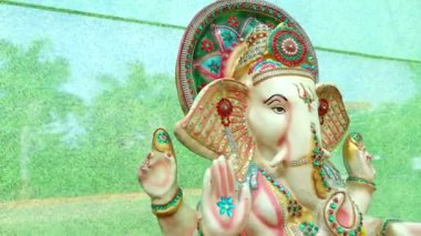 Tanrı Ganesha 'nın büyük heykeli. Renkli heykel. Fil Yüzlü Tanrı. Yeşil arka plan. Ana Hindu Tanrısı. Hinduizm Din ve Kültür.