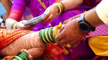 Gelin ve damadın elleri zerdeçal iplikli seremonide. Hindu düğün ritüeli. Marathi Düğünü