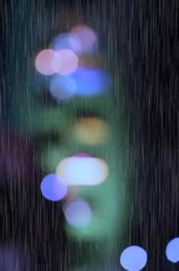 Yağmur damlaları ve ışıklar. Islak cam pencere. Yağmur zemini. Yağmur mevsimi. Rahatla.