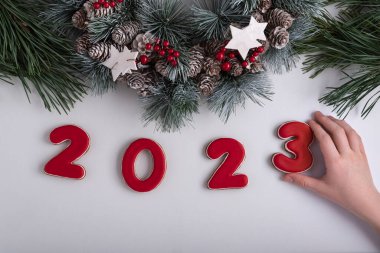 Zencefilli kurabiyeden 2023 yazıtları, kurabiye alan çocuk eli. Yeni yıl ve Noel dekoru.