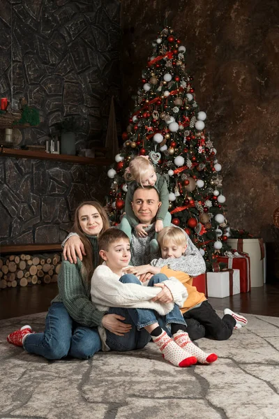 Portrait of big happy family at home near xmas tree. Three children and parents. Family Christmas Eve