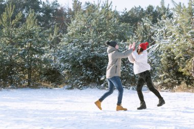 Genç adam ve kız kışın dışarıda oynuyorlar. Kadın ve erkek arasındaki arkadaşlık. En iyi arkadaşlar