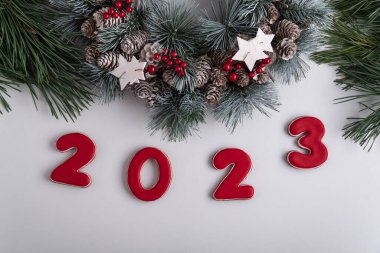 2023 yazıtları ve Noel çelengi, üst manzara. Beyaz arka plan. Mutlu yıllar 2023.