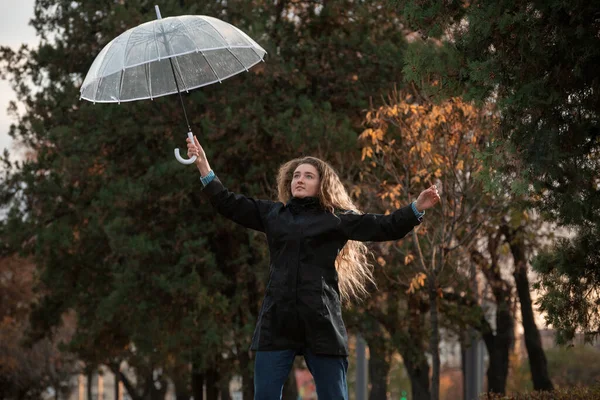 Lächelnd Springt Ein Junges Studentenmädchen Mit Durchsichtigem Regenschirm Auf Die — Stockfoto