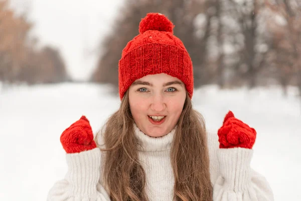 白いウールのセーター 赤い帽子 冬の屋外でのミトンで楽しい女の子の肖像画 暖かいニットの服の女性 — ストック写真