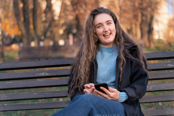 Cheerful Girl Long Brown Hair Sits Park Bench Uses Her — Stock Photo, Image