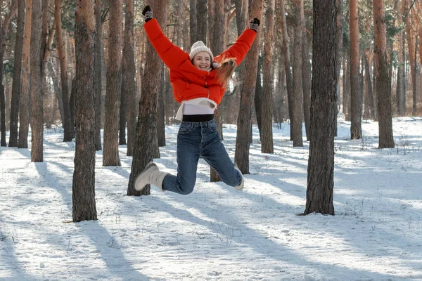 阳光明媚的日子 走过冬日的树林 在雪地的森林里快乐的年轻女子跳得很高 — 图库照片