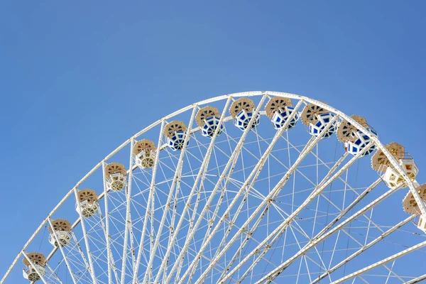 Ferris wheel on the blue sky background. Old rusty Ferris wheel. Attractions and recreation park