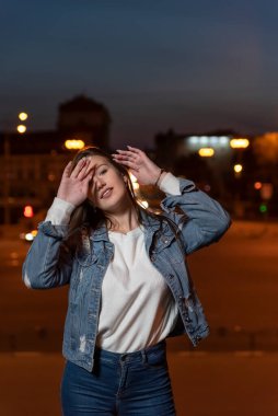 Girl straightens her hair before photographing. Vertical frame.