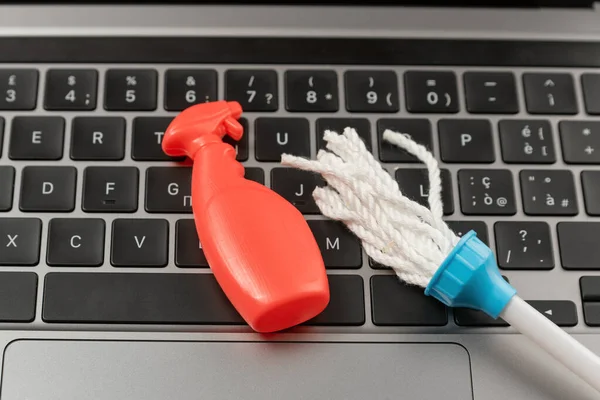 Toy small cleaning tools on the laptop keyboard. Cleaning keyboard or program system. Online order cleaning services. Search for cleaner