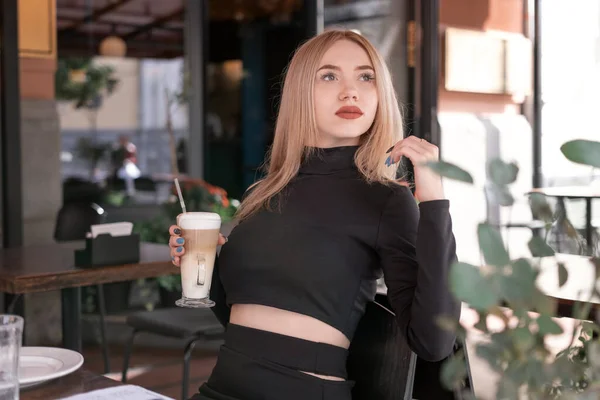 Задумчивая Привлекательная Молодая Блондинка Сидит Столом Кафе Чашкой Кофе Капучино — стоковое фото