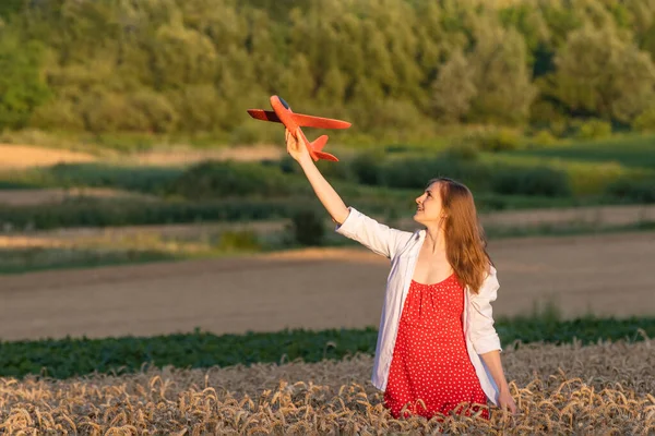 Mladá Žena Červených Šatech Bílé Košili Modelem Letadla Ruce Pole — Stock fotografie