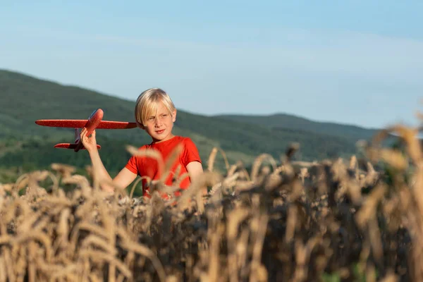 Chlapec Červeném Tričku Hraje Letadýlkem Pšeničném Poli Koncept Letů Cestování — Stock fotografie