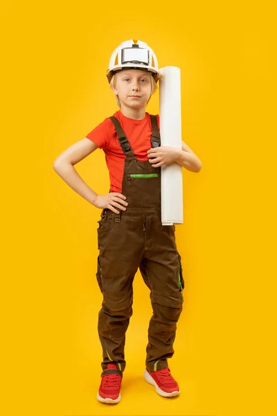 戴防护头盔 穿工作服 手里拿着纸卷的小男孩 作为建设者或建筑师的孩子 垂直框架 — 图库照片