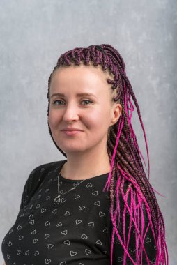 Menekşe desenli saçları olan çekici bir kadın. Korkulu orta yaşlı kadın portresi. Gri arka plan. Dikey çerçeve