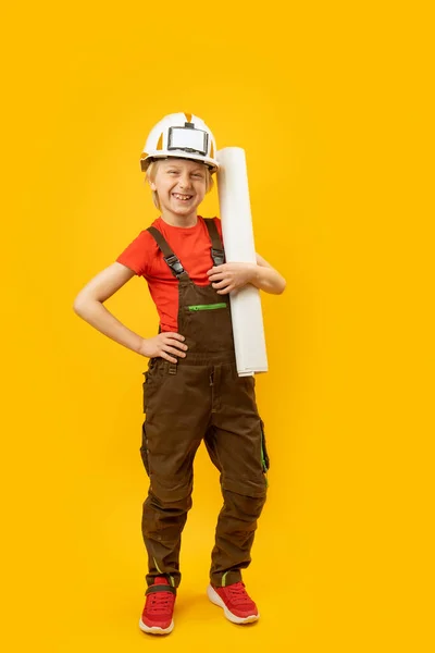 보호용 헬멧을 작업복을 종이를 미소짓는 건축자나 건축가로서의아이 수직적 — 스톡 사진