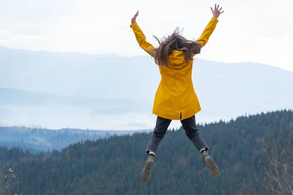 stock image Jumping young woman on top of mountain. Concept of freedom. Happy tourist woman conquered the top.