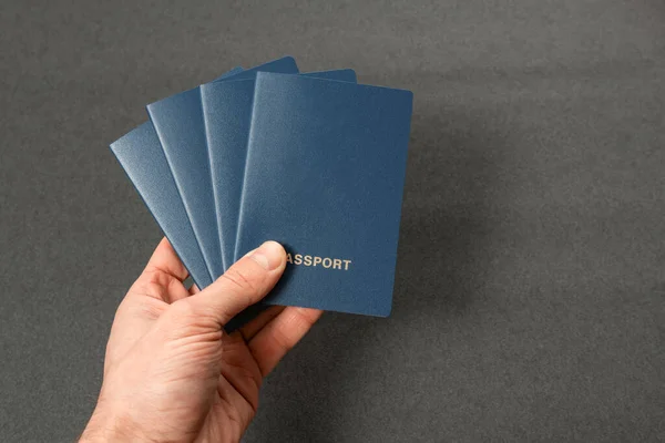 Quatro Passaportes Azuis Com Capas Branco Mão Dos Homens Sobre — Fotografia de Stock