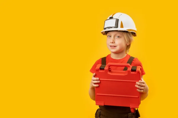 将金发碧眼的男孩儿的画像在黄色背景下隔热 用塑料盒装饰在白色防护头盔上 复制空间 — 图库照片