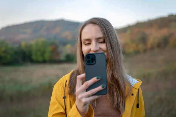 Smiling Girl Yellow Jacket Uses Smartphone While Walking Autumn Day — Stock Photo, Image