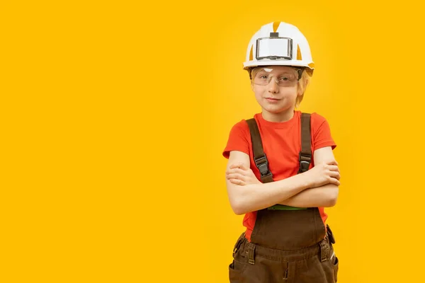 穿着工作服的男孩 戴着黄色背景的防护头盔和眼镜 选择的职业 复制空间 — 图库照片