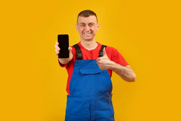 Hombre Joven Mono Azul Camiseta Roja Sostiene Teléfono Inteligente Con —  Fotos de Stock