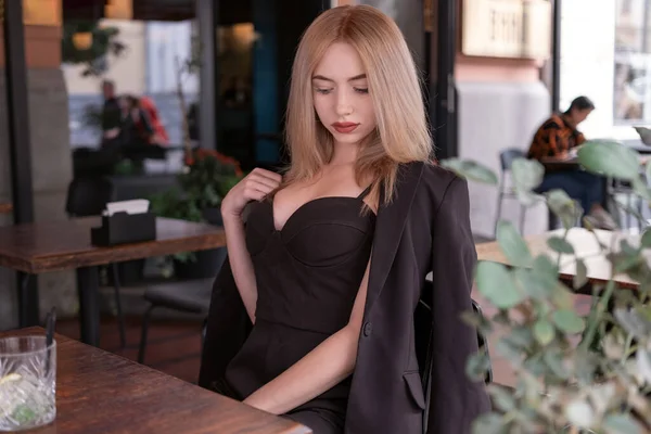 Sexy Mladá Blondýna Černém Obleku Sedí Kavárně Čeká Objednávku Moderní — Stock fotografie