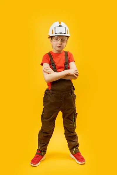 穿着头盔和工作服的工人玩耍的男孩 儿童在黄色背景下作为建设者的肖像 复制空间 — 图库照片