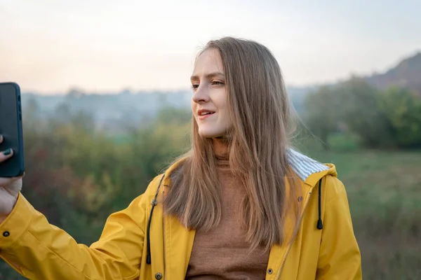 Young Woman Photographs Beautiful Landscape Smart Phone Girl Yellow Jacket — Stock Photo, Image