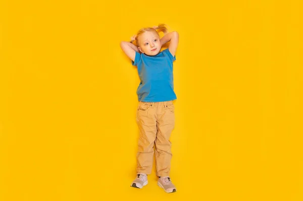 Маленька Дівчинка Двома Хвостами Носить Синю Футболку Жовті Штани Лежать — стокове фото
