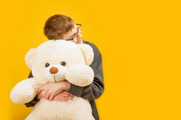 Tienerjongen Met Glazen Knuffels Grote Teddybeer Geïsoleerd Gele Achtergrond Kopieer — Stockfoto