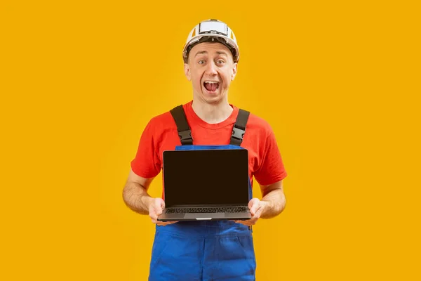 Jóképű Férfi Művezető Mérnök Laptopot Tart Üres Képernyővel Sárga Háttéren — Stock Fotó