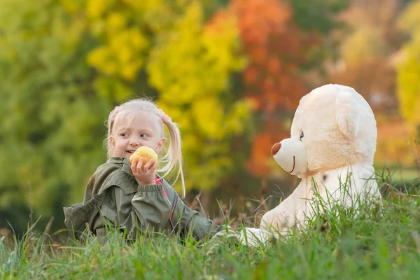 Μικρή Ξανθιά Κοπέλα Τρώει Μήλο Και Παίζει Μεγάλο Αρκουδάκι Κάθεται — Φωτογραφία Αρχείου