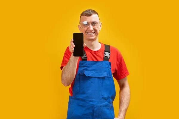 Homem Trabalhador Uniforme Óculos Detém Telefone Celular Preto Com Tela — Fotografia de Stock