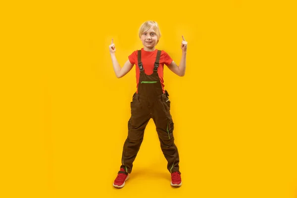 仕事中の白人の10代の少年は 足が広がり 人差し指を上に向けて立っている スペースのコピー — ストック写真