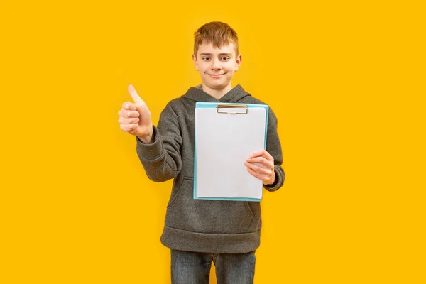 Европейский Подросток Держит Чистые Белые Листы Бумаги Показывает Большие Пальцы — стоковое фото